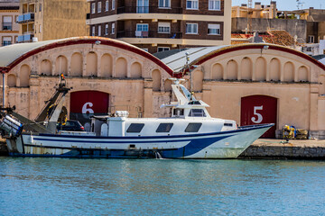 Beautiful long white boat with blue stripes in the port of Gandia, Spain	
