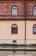 Symmetrical brick and stucco wall with arched windows.