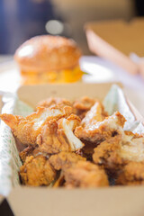 Korean deep dried chicken in paper brown take out box.