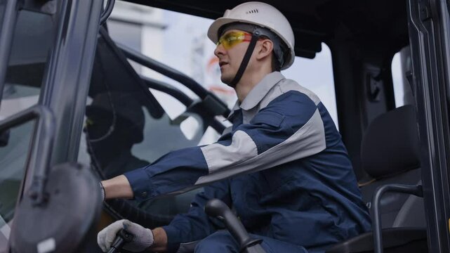 Man driver builder operate crane or excavator at construction site with sun light. Portrait Industry worker.