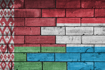 Fototapeta premium colourful painted big national flag of belarus and flag of luxembourg on a massive old brick wall background. concept