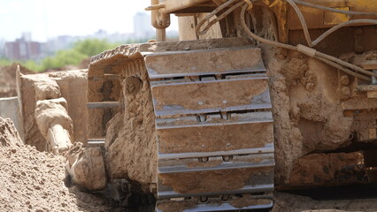 Fototapeta premium A bulldozer caterpillar. A bulldozer is clearing a site for construction. Bulldozer removes sand.