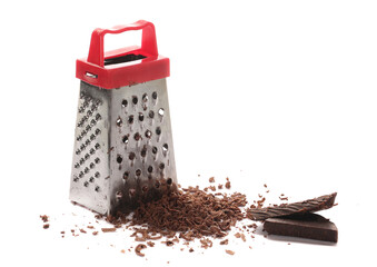 Kitchen grater and pile chopped, dark chocolate isolated on white background