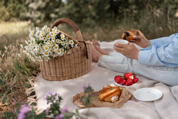 Picnic Flowers Pastries: Woman enjoys pastry, coffee, strawberries from basket during idyllic...