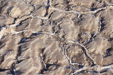 The dry and cracked surface of the Dead Sea in Jordan showcases intricate salt formations under...