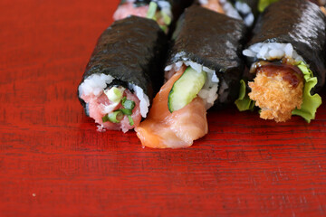 漆塗りの板にのせた様々な種類の巻きずし