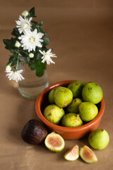 Fresh Green Figs in Bowl With White Daisies in Glass Vase