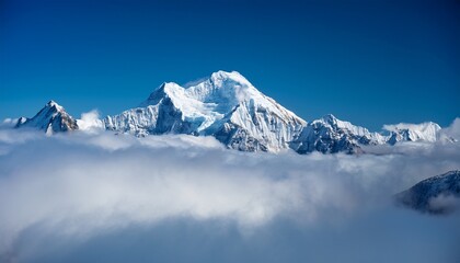 Naklejka premium majestic snow capped mountain peak piercing through a sea of clouds under a deep blue sky