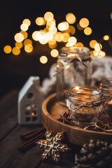 Aromatic christmas handmade candle with the sweet scent of gingerbread cookies. Cozy holiday home atmosphere, aromatherapy. Interior composition with burning candles, anise, cinnamon, pine cones