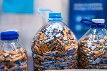 Plastic bottles collecting cigarette butts for environmental awareness
