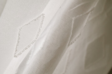 Obraz premium Boho Chic in White | Close-up of a Curtain with Bohemian-Style Embellishments | Boho-Details in Weiß | Nahaufnahme eines Vorhangs mit Applikationen im Boho-Stil