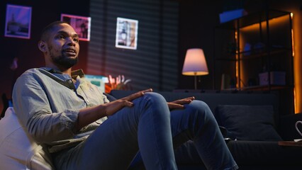 African american person smiling and chatting during a video call at home, sharing insight for tasks completion with colleagues on web meeting. Digital and wireless lifestyle. Camera A.