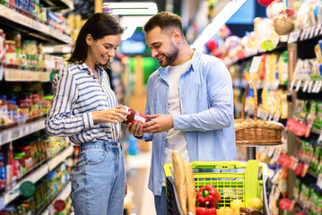 Customers In Super Market Concept. Young Family Couple Doing Grocery Shopping In Supermarket...