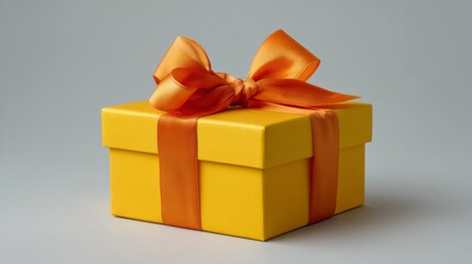 Obraz premium An orange and yellow gift box tied with a neat bow, ready to be given as a special occasion or celebration present.