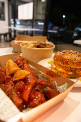 Korean deep dried spicy red chicken sauce in a paper takeaway box.