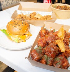 Korean deep dried spicy red chicken sauce in a paper takeaway box.