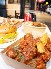 Korean deep dried spicy red chicken sauce in a paper takeaway box.