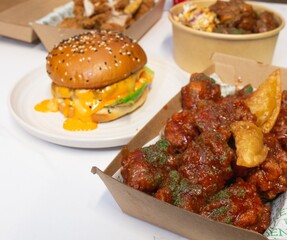 Korean deep dried spicy red chicken sauce in a paper takeaway box.