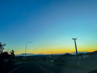Driving through highway on the coastline at sunset in Auckland, New Zealand.