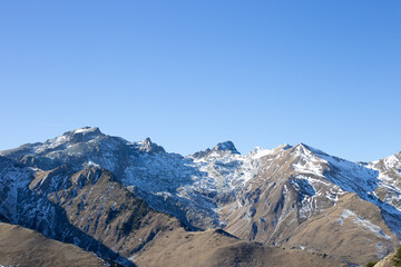 Panorama di montagne innevate sotto cielo limpido d’inverno..