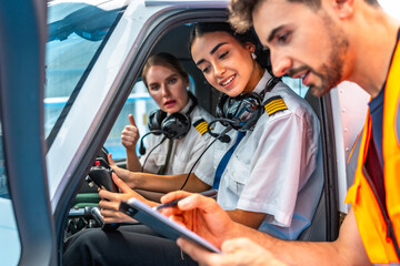 Flight instructor explaining pre flight checklist to female pilots inside cockpit