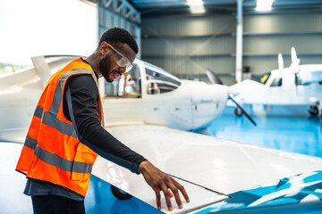 Aircraft maintenance engineer inspecting airplane wing in hangar © unai