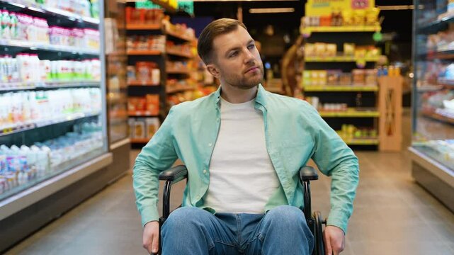 Customer sitting in wheelchair looking at shelves in supermarket