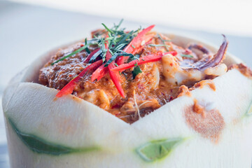 Close up of Steamed curry seafood in young coconut,selective focus