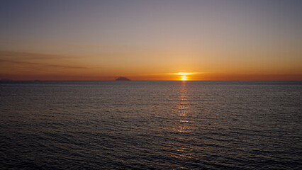 Sunset over Tyrrhenian Sea with Stromboli volcano silhouette and colorful sky