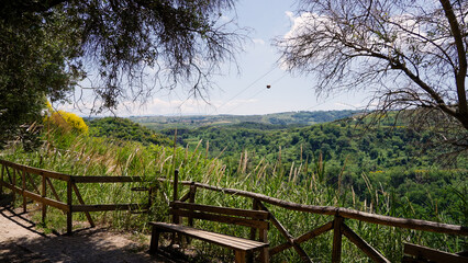 Cable car cabin hovering over the lush green valley in Zungri, Calabria, offering breathtaking panoramic views