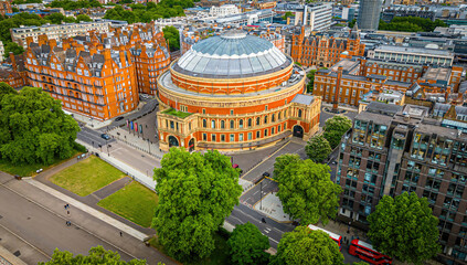Aerial view of the Royal Albert Hall in London, surrounded by classic red-brick buildings, roads, and green trees
