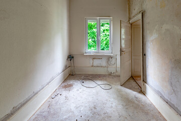 enovated room with plaster wall and wooden panels at the floor before covered by woodchip wallpaper after wall plastering