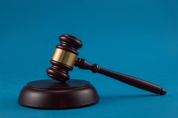 Elegant wooden gavel on blue background