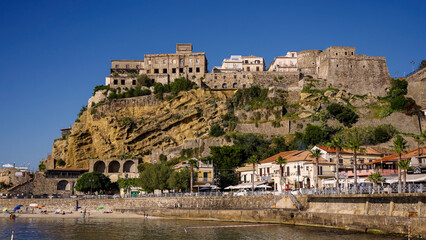 Naklejka premium Pizzo Calabro, a picturesque town in Calabria, Italy, perches atop a cliff overlooking the beach, bathed in the warm sunlight of a perfect summer day