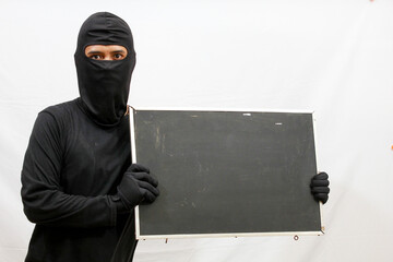 black clothed thief holding black board caught,isolated white background
