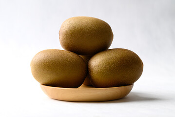 Fresh kiwi fruit on wooden plate with white background, Healthy fruit