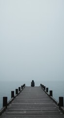 Obraz premium Solitude on a Misty Pier: A Person Contemplates Life's Mysteries by the Calm Lake