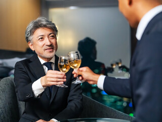 都市の夜景を背景に乾杯する多国籍ビジネスパーソン