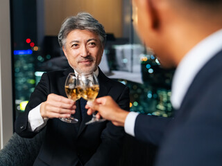 都市の夜景を背景に乾杯する多国籍ビジネスパーソン