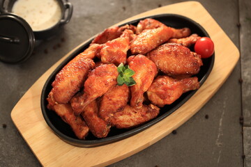 Korean-style fried chicken wings and drumsticks served in a skillet. Crispy texture with sweet and spicy glaze. A popular K-Food dish enjoyed at home and in restaurants.
