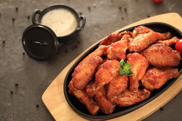 Korean-style fried chicken wings and drumsticks served in a skillet. Crispy texture with sweet and spicy glaze. A popular K-Food dish enjoyed at home and in restaurants.
