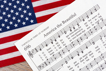 The America the Beautiful sheet music on top of an American Flag