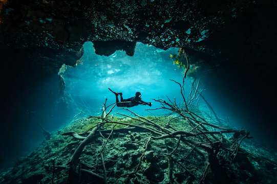Scuba diver posing at the entrance of Cenote Aktun Ha in Tulum, Mexico