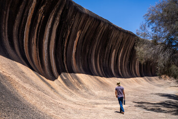 Person walking near iconic Wave Rock formation in Western Australia