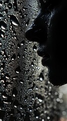 Silhouette of a face behind a wet glass window with droplets of water