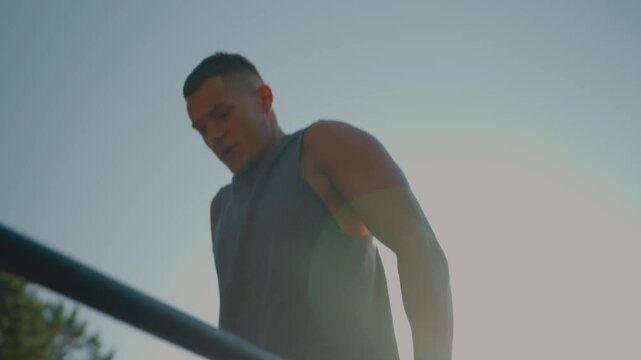 A fit man performs exercises on parallel bars outdoors during sunrise, highlighting strength, fitness, and determination. Perfect image for health, wellness, and exercise concepts. Man Exercising 