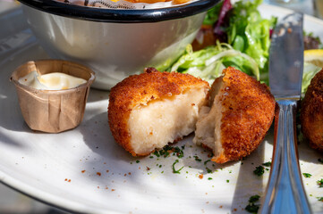 Lunch in cafe with vegetarian cheese and green asparagus croquettes served with fresh salad and french fries potato in Bruges, Belgium