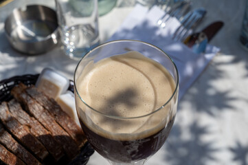 Belgian beer in glass in old brewery in Bruges, dubbel dark, tasty beverage, lunch with beer, tourist destination, Flanders, Belgium