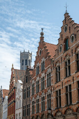 Fototapeta premium Medieval houses facades and rooftops and city tower with bells in the centre of Bruges, Flanders