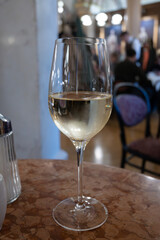 Lifestyle of beautiful Vienna, glass of cold white dry Austrian wine served in old Viennese-style cafe in Vienna, Austria